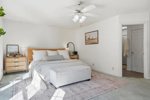 a view of an empty room with chandelier fan