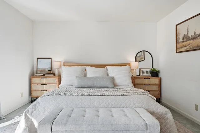 an empty room with a chandelier fan and windows