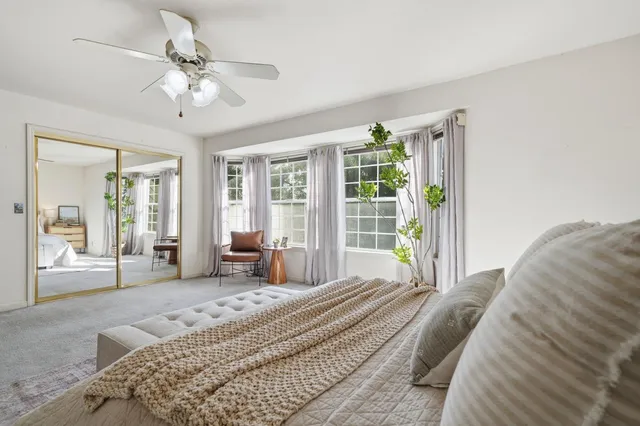 a living room with furniture kitchen view and a large window