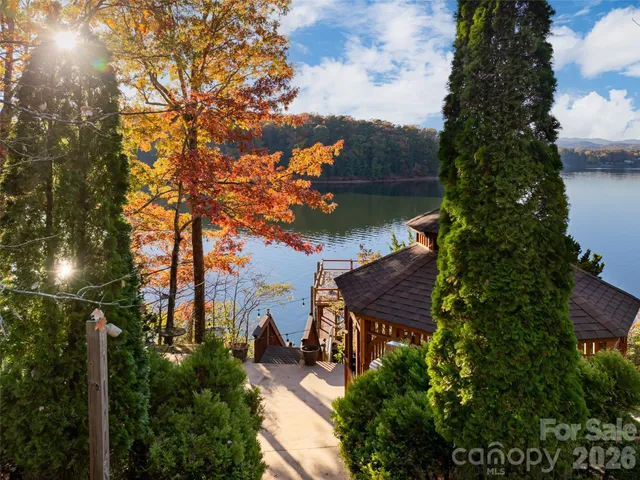 a dining room with wooden floor a chandelier a wooden table and chairs