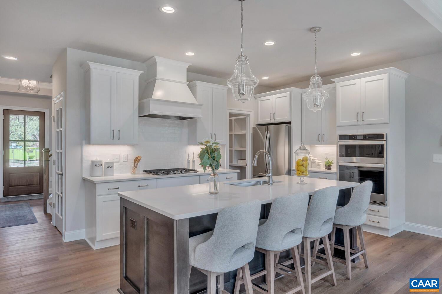 115 Riparian Court, Unit B Charlottesville, VA 22911 - Photo 13 of 58 a kitchen with stainless steel appliances kitchen island granite countertop a table chairs sink and cabinets
