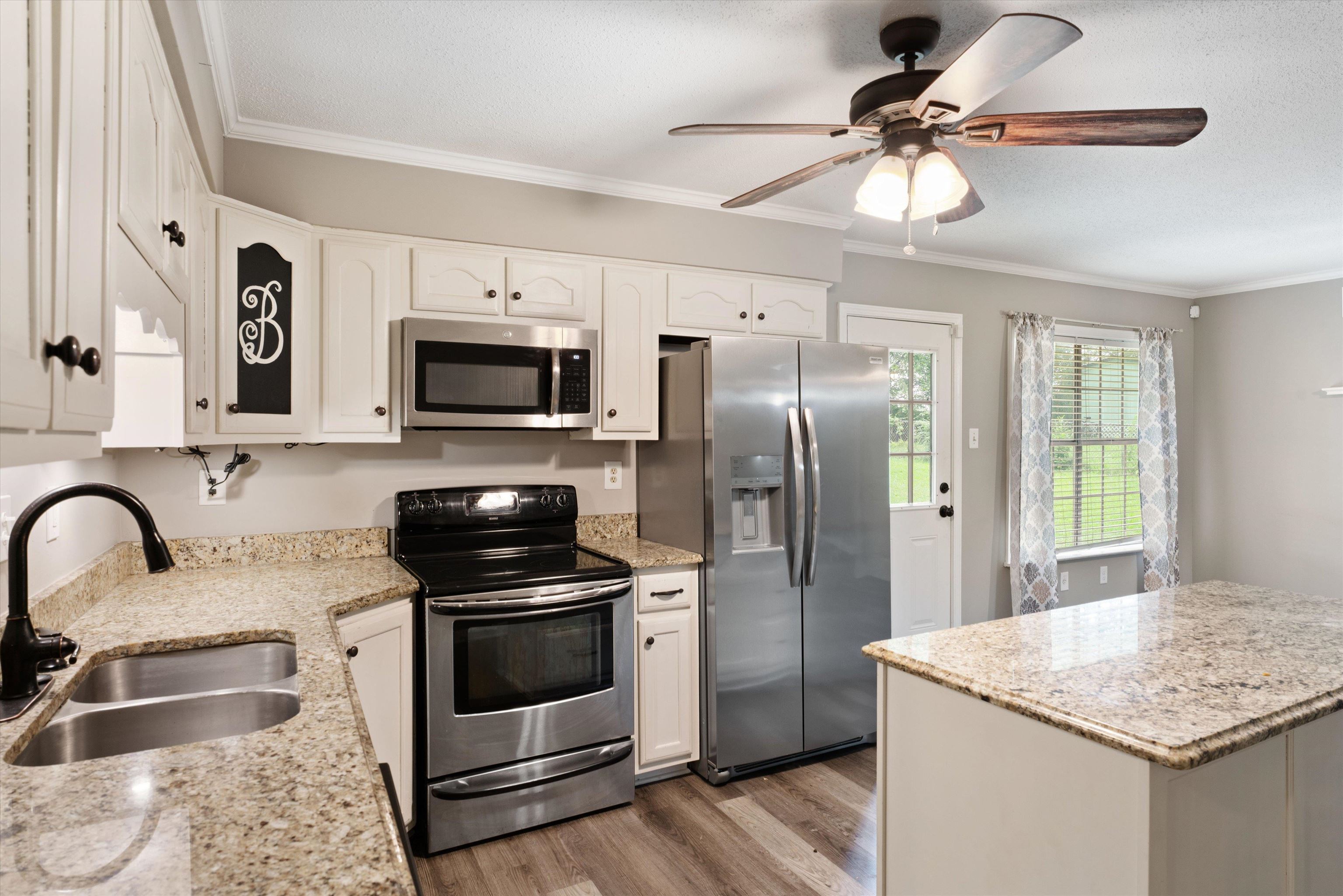 960 Greenview Road Collierville, TN 38017 - Photo 10 of 23 a kitchen with stainless steel appliances granite countertop a sink a stove a refrigerator cabinets and a dining table