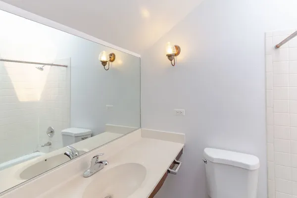 a bathroom with a sink and mirror with toilet