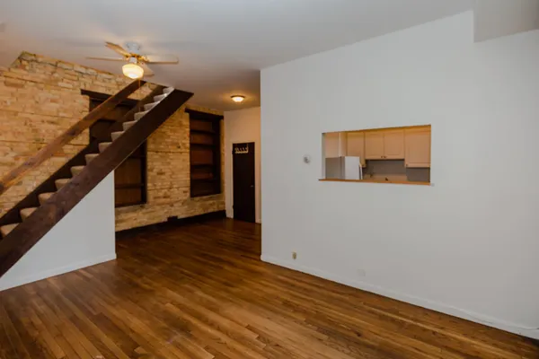 a view of a hallway with wooden floor and staircase