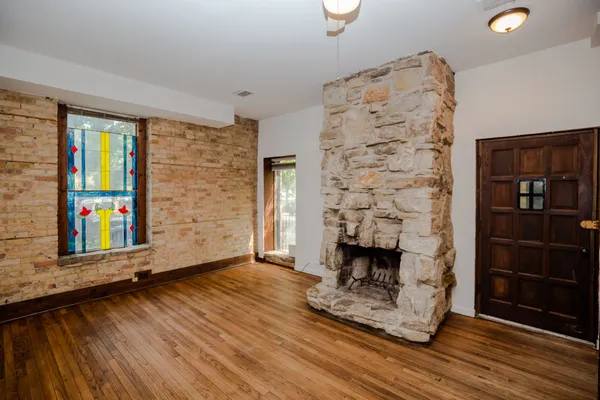 wooden floor fireplace and windows in an empty room