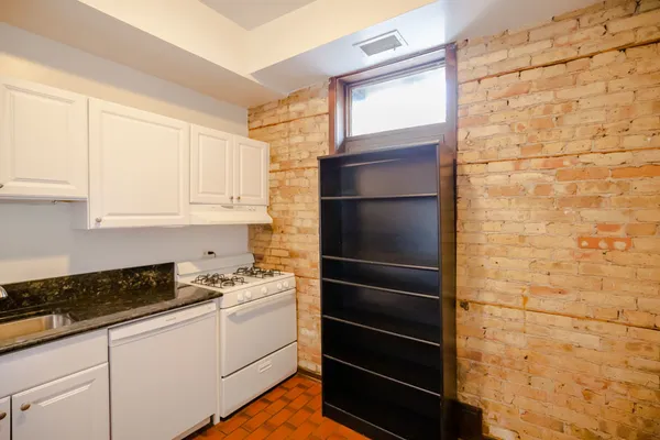 a kitchen with a refrigerator and white cabinets