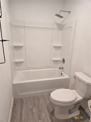 a bathroom with a toilet and a bath tub