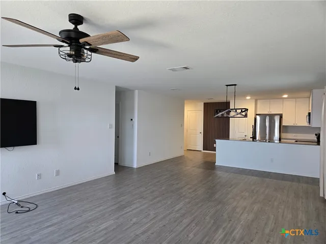a view of a living room hardwood floor and a ceiling fan