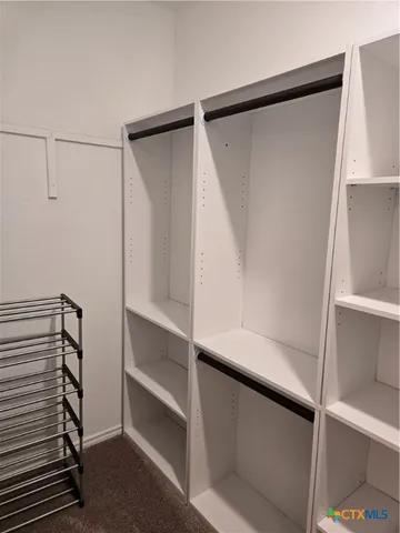 a view of walk in closet with empty racks