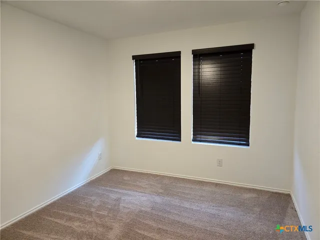 an empty room with a window and closet