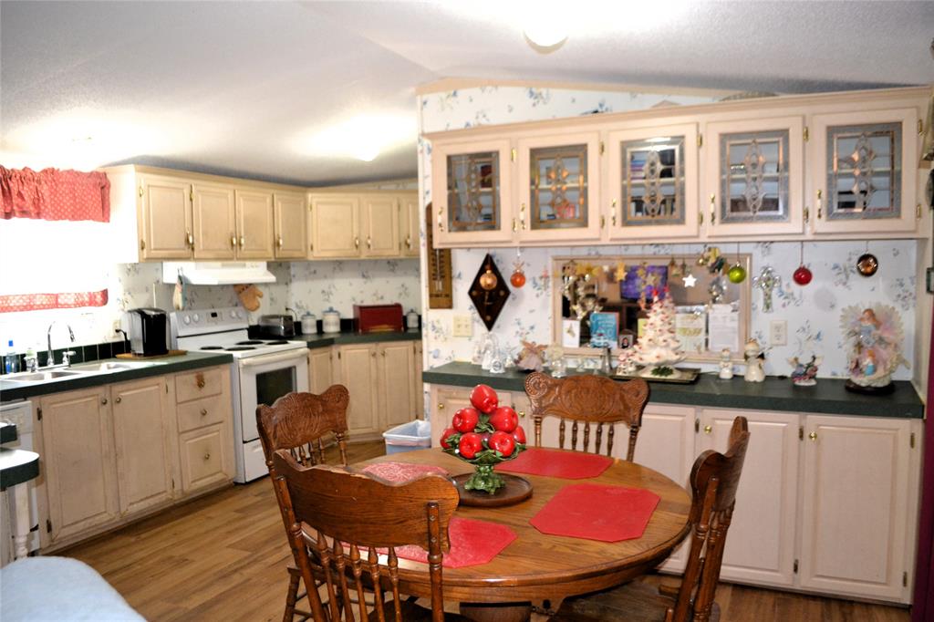 174 Kickapoo Quitman, TX 75783 - Photo 11 of 25 a kitchen with stainless steel appliances granite countertop a dining table chairs and stove top oven with wooden floor