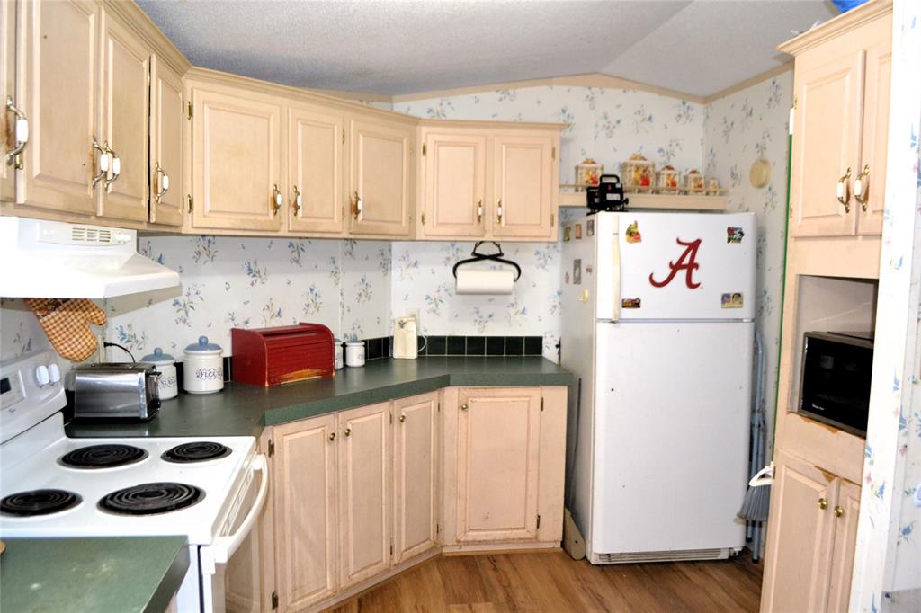 174 Kickapoo Quitman, TX 75783 - Photo 12 of 25 a kitchen with stainless steel appliances a refrigerator a sink and white cabinets