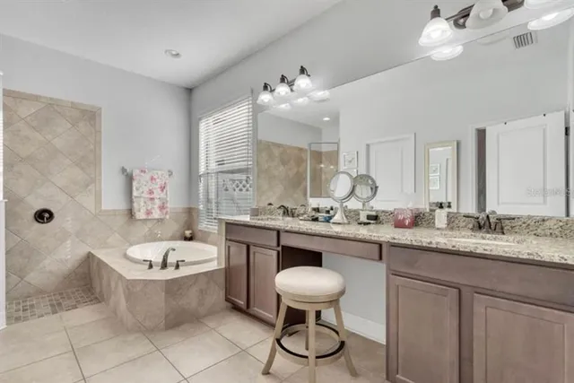 a bathroom with a granite countertop sink mirror bathtub and toilet