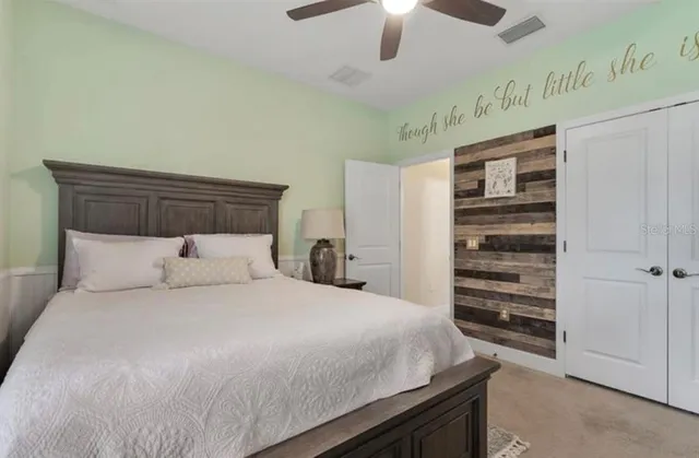 a bedroom with a bed and a ceiling fan