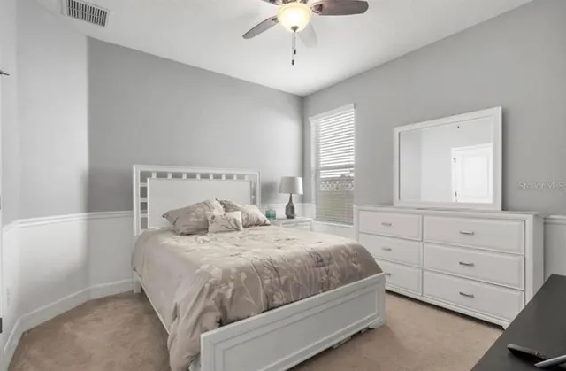 a bedroom with a bed a chandelier and a window