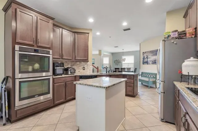a kitchen with kitchen island granite countertop appliances cabinets and a sink