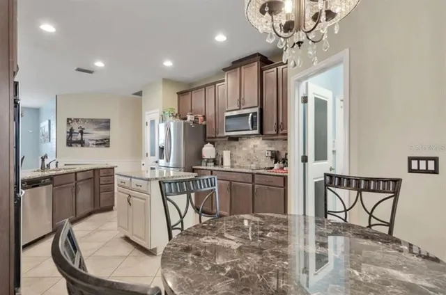 a kitchen with kitchen island granite countertop a sink cabinets and stainless steel appliances