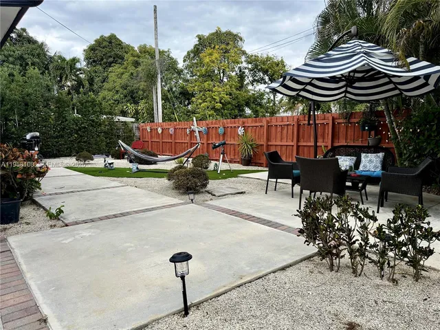 a view of a patio with a table and chairs under an umbrella