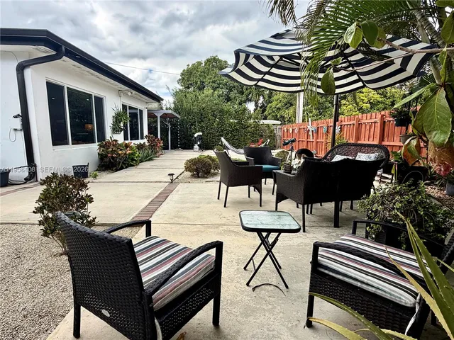 a backyard of a house with table and chairs