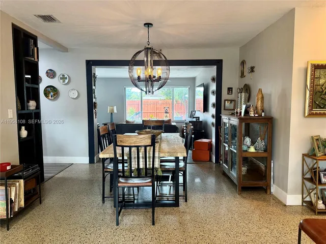 a view of a dining room with furniture and a chandelier