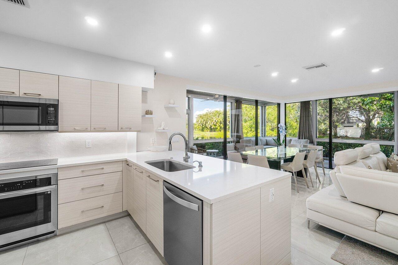 19173 Sabal Lake Drive, Unit 5155 Boca Raton, FL 33434 - Photo 11 of 33 a kitchen with a sink stove top oven and cabinets