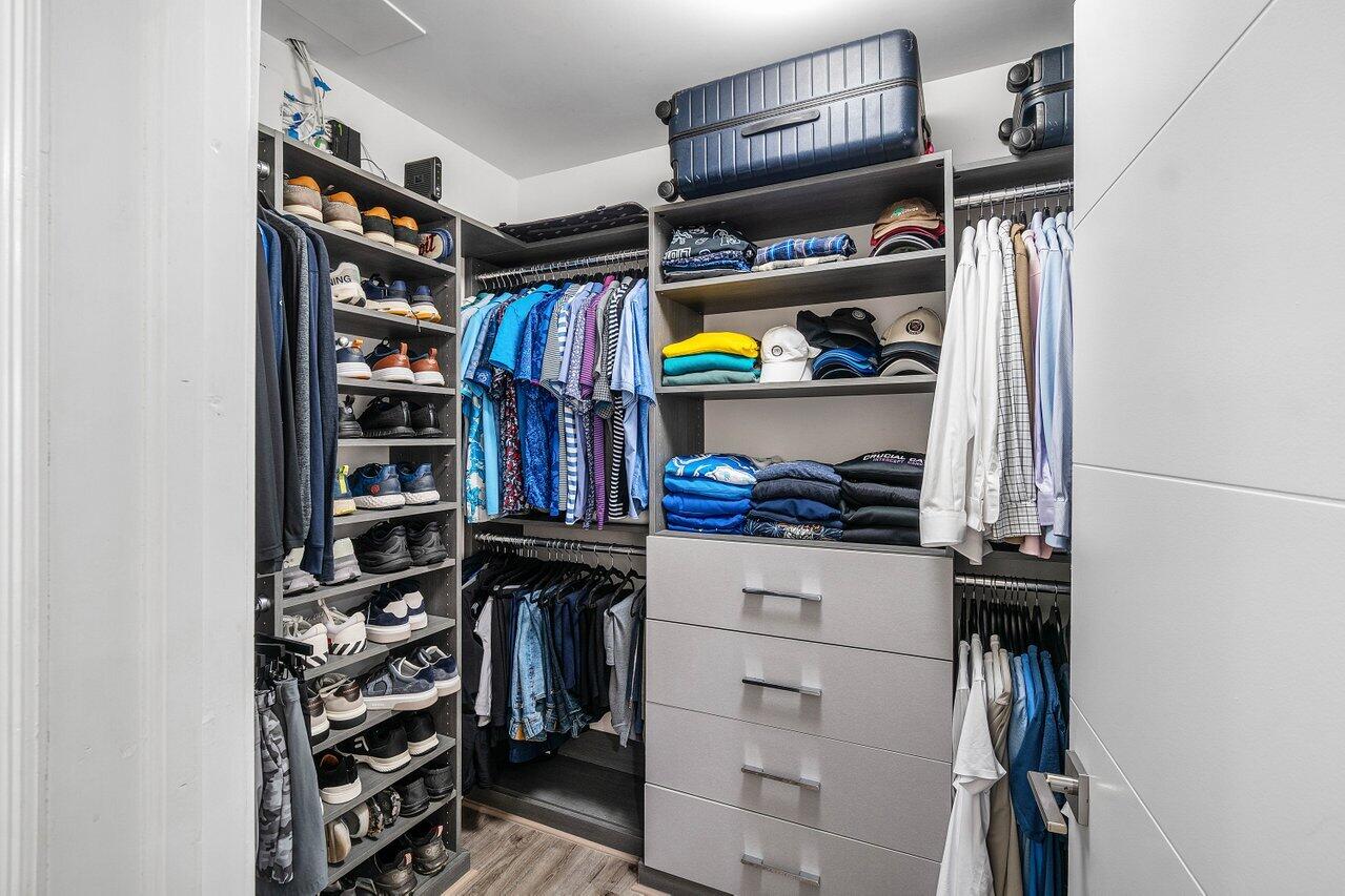 19173 Sabal Lake Drive, Unit 5155 Boca Raton, FL 33434 - Photo 19 of 33 a view of walk in closet with clothes and shoes
