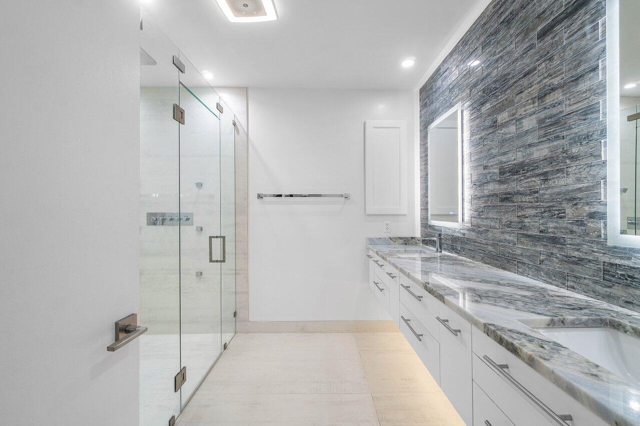 19173 Sabal Lake Drive, Unit 5155 Boca Raton, FL 33434 - Photo 20 of 33 a bathroom with a granite countertop bathtub shower sink and mirror