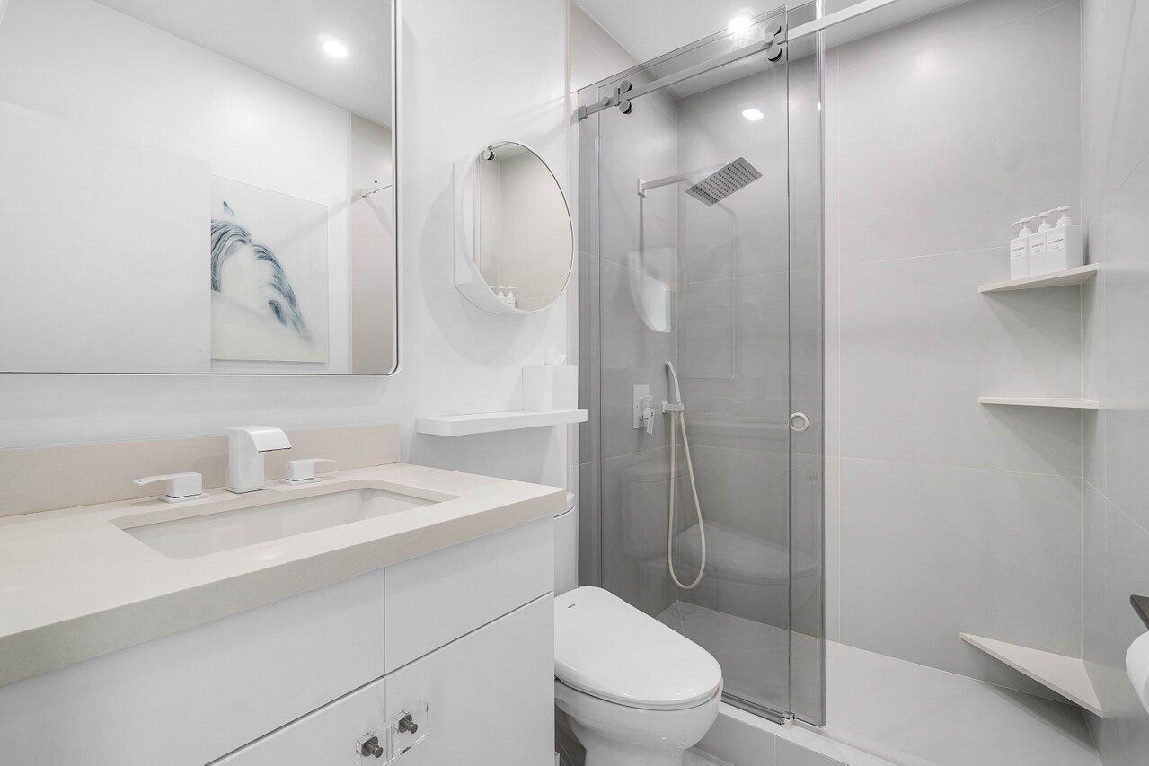 19173 Sabal Lake Drive, Unit 5155 Boca Raton, FL 33434 - Photo 27 of 33 a bathroom with a sink a toilet and shower
