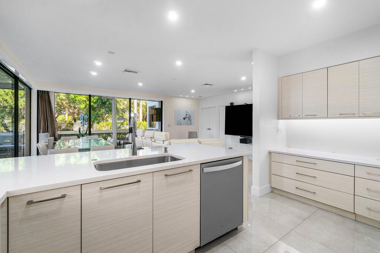 19173 Sabal Lake Drive, Unit 5155 Boca Raton, FL 33434 - Photo 10 of 33 a kitchen with white cabinets and sink