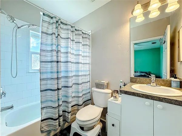 a bathroom with a sink a toilet a mirror and shower