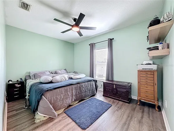a bedroom with a bed and wooden floor