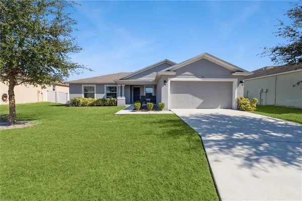 a front view of a house with a yard and trees