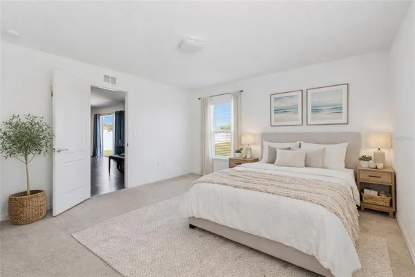a bedroom with a bed and a potted plant