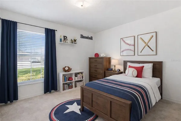 a bedroom with a bed and a dresser next to a window