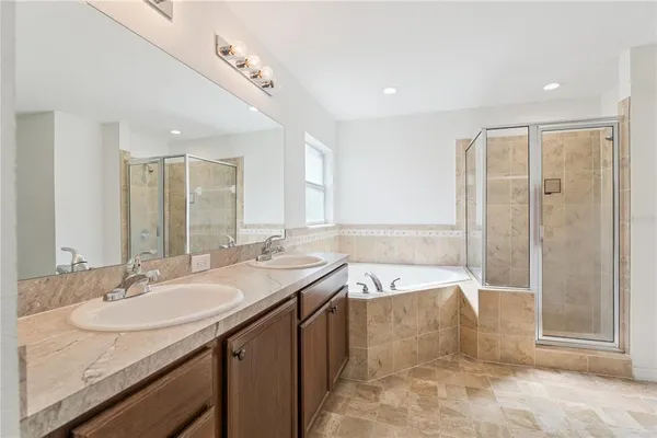 a bathroom with a granite countertop sink a mirror and a bathtub