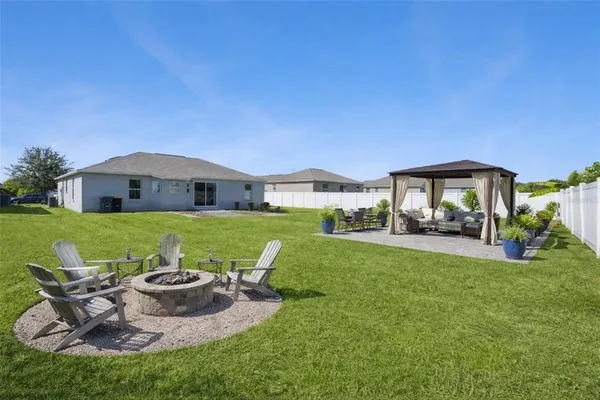 a view of house with backyard and outdoor seating