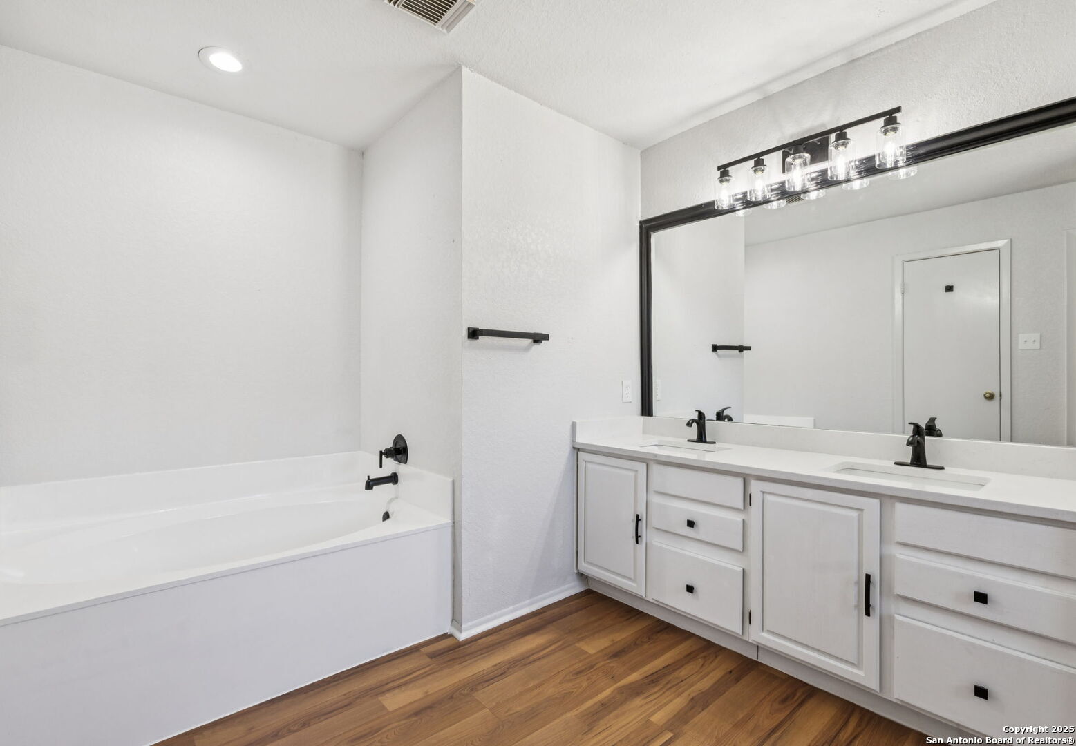 8127 Talkenhorn Converse, TX 78109 - Photo 49 of 57 a bathroom with a double vanity sink a mirror and a bathtub