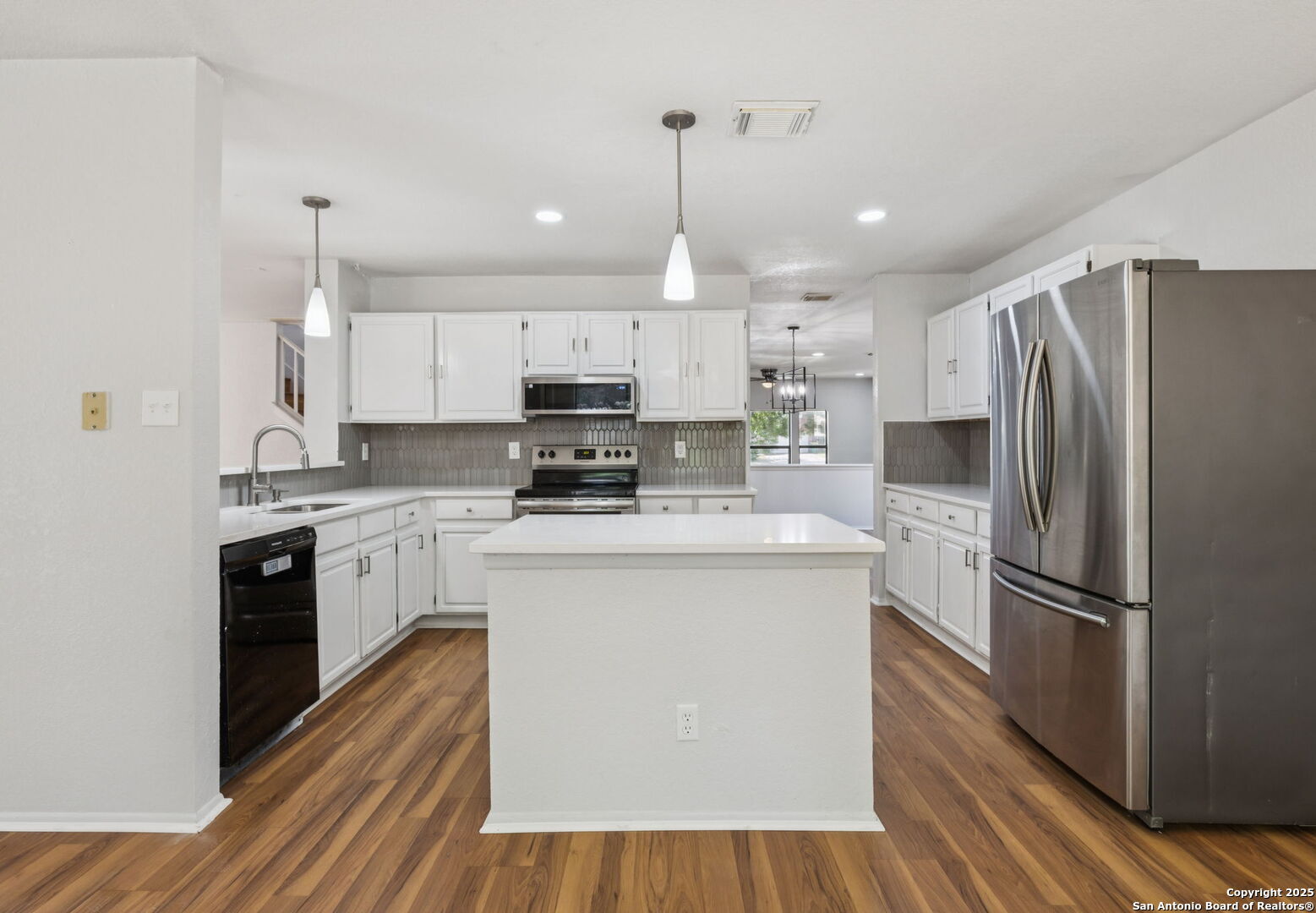8127 Talkenhorn Converse, TX 78109 - Photo 10 of 57 a kitchen with kitchen island white cabinets and stainless steel appliances