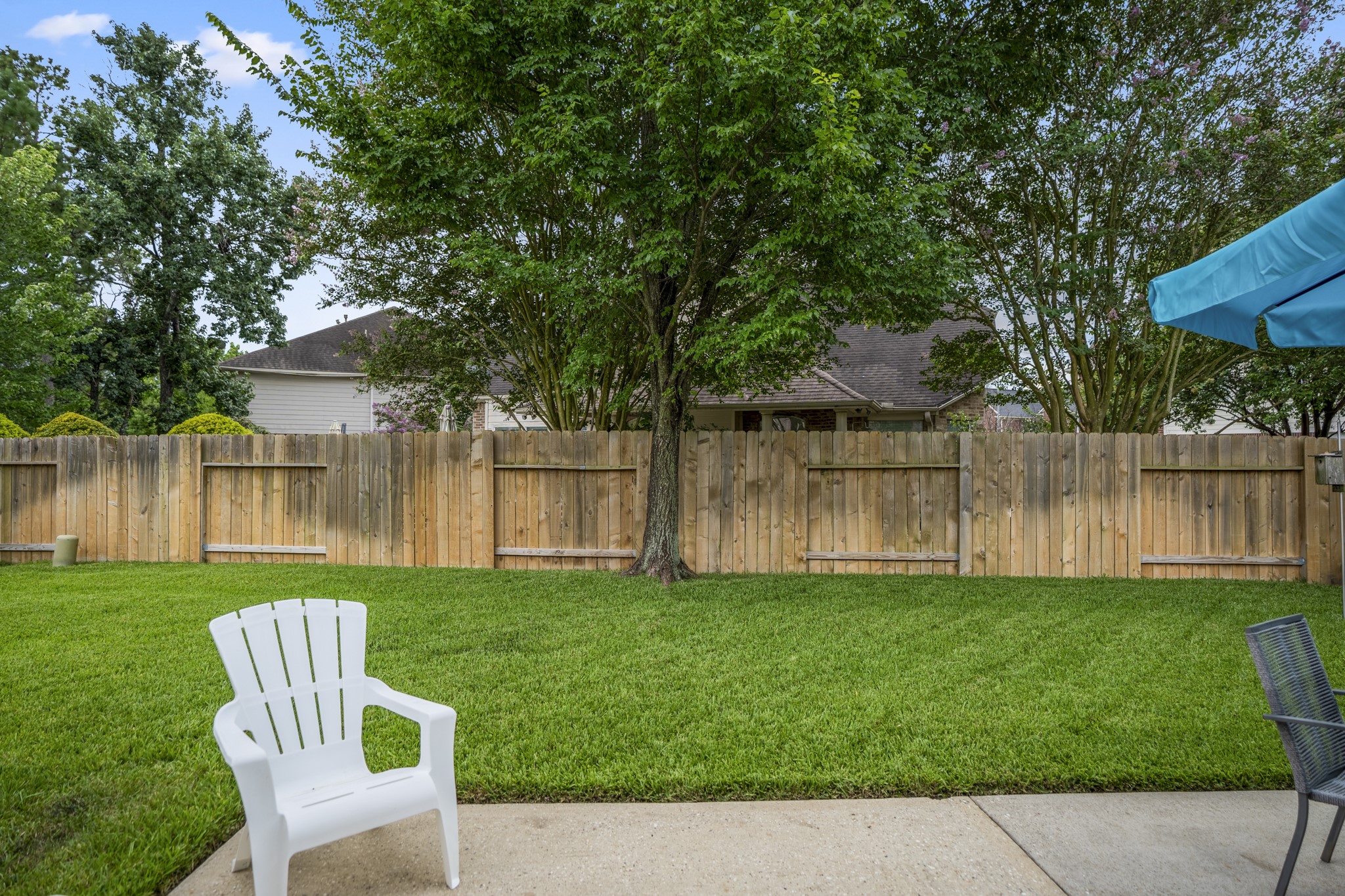 3411 Utah Beach Court Spring, TX 77388 - Photo 36 of 50 Beyond the patio, the fenced backyard offers open lawn space with surrounding greenery along the back fence for a more comfortable outdoor feel. This view gives buyers a better sense of the yard’s depth and how the outdoor area extends beyond the seating space just off the home.