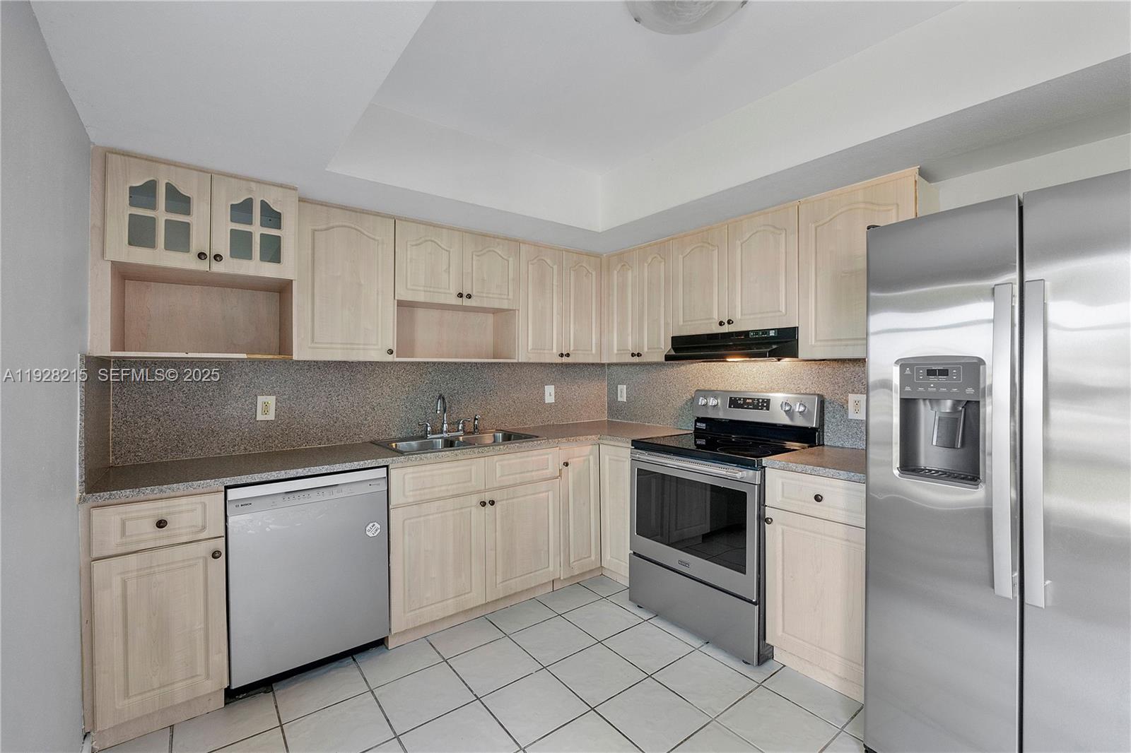 5850 Northwest 57th Avenue, Unit 1 Tamarac, FL 33319 - Photo 28 of 56 a kitchen with white cabinets sink and stainless steel appliances