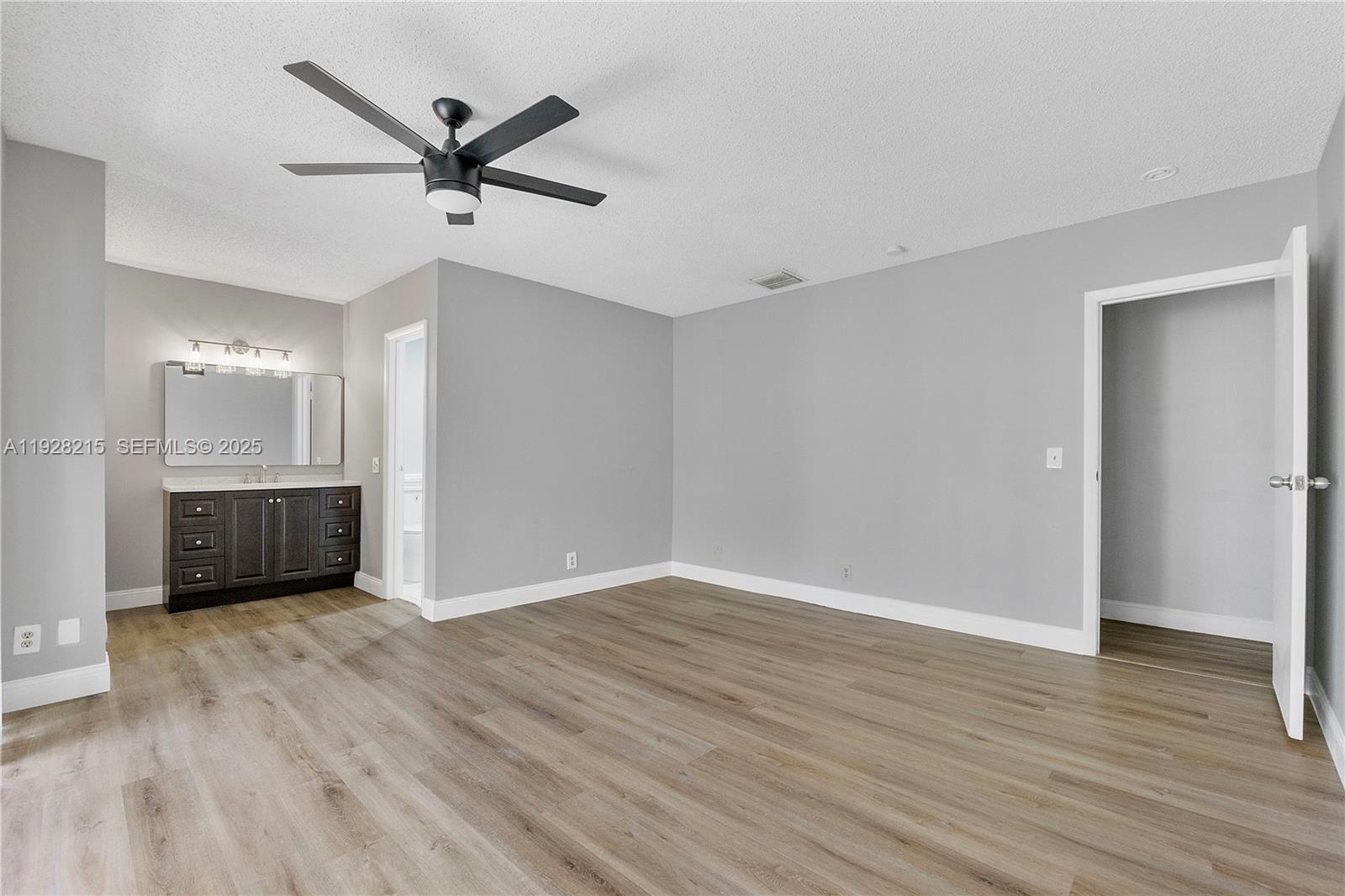 5850 Northwest 57th Avenue, Unit 1 Tamarac, FL 33319 - Photo 30 of 56 an empty room with wooden floor cabinet and windows