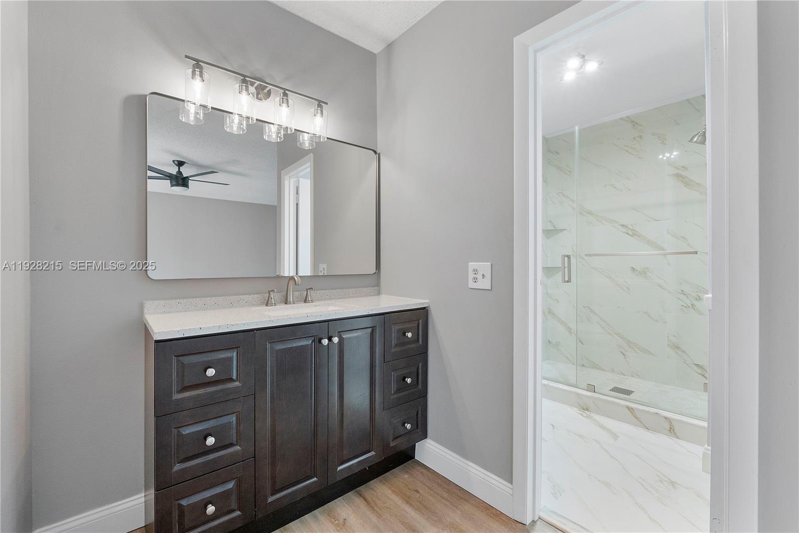 5850 Northwest 57th Avenue, Unit 1 Tamarac, FL 33319 - Photo 38 of 56 a bathroom with a granite countertop sink a shower and a mirror