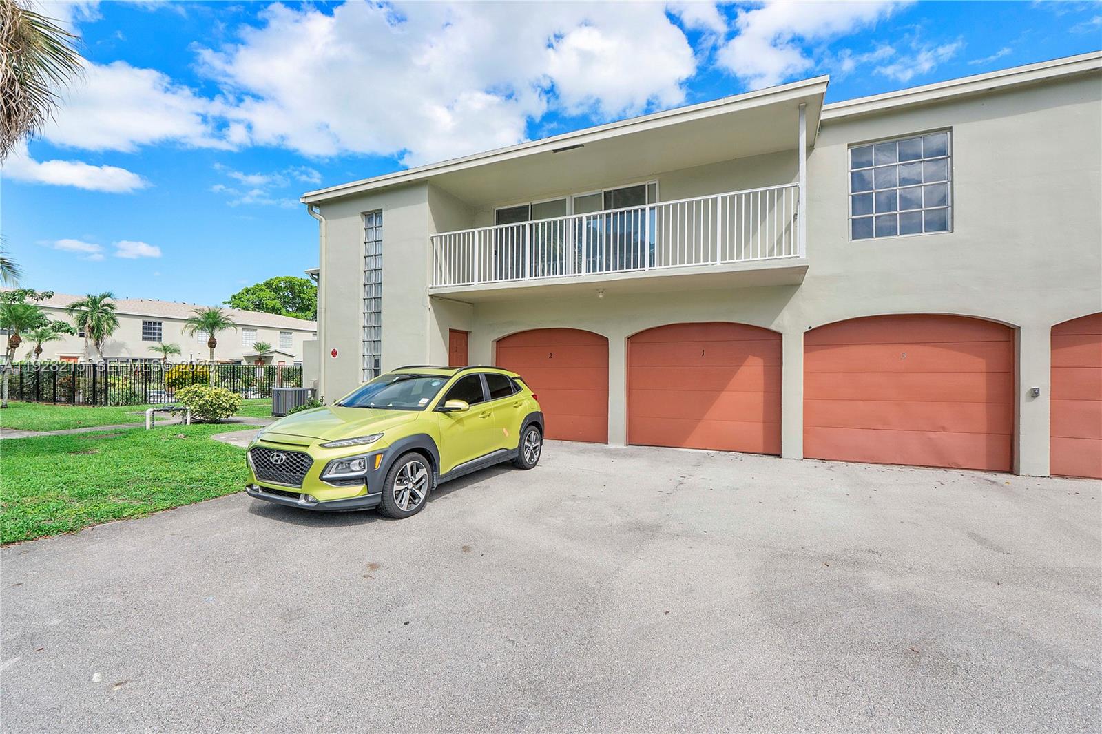 5850 Northwest 57th Avenue, Unit 1 Tamarac, FL 33319 - Photo 53 of 56 a car parked in front of a house with a yard