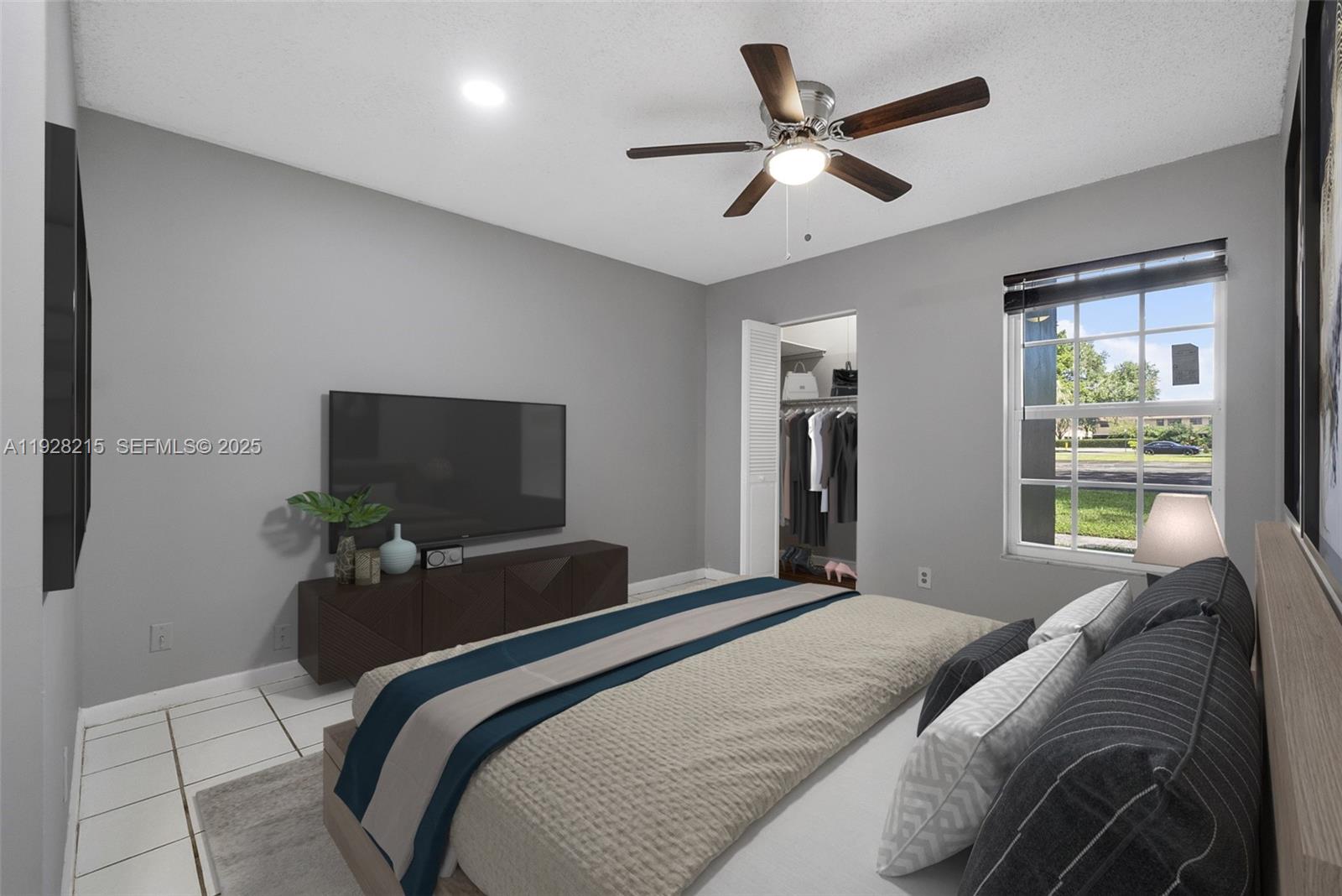 5850 Northwest 57th Avenue, Unit 1 Tamarac, FL 33319 - Photo 10 of 56 a bedroom with a bed and a flat screen tv