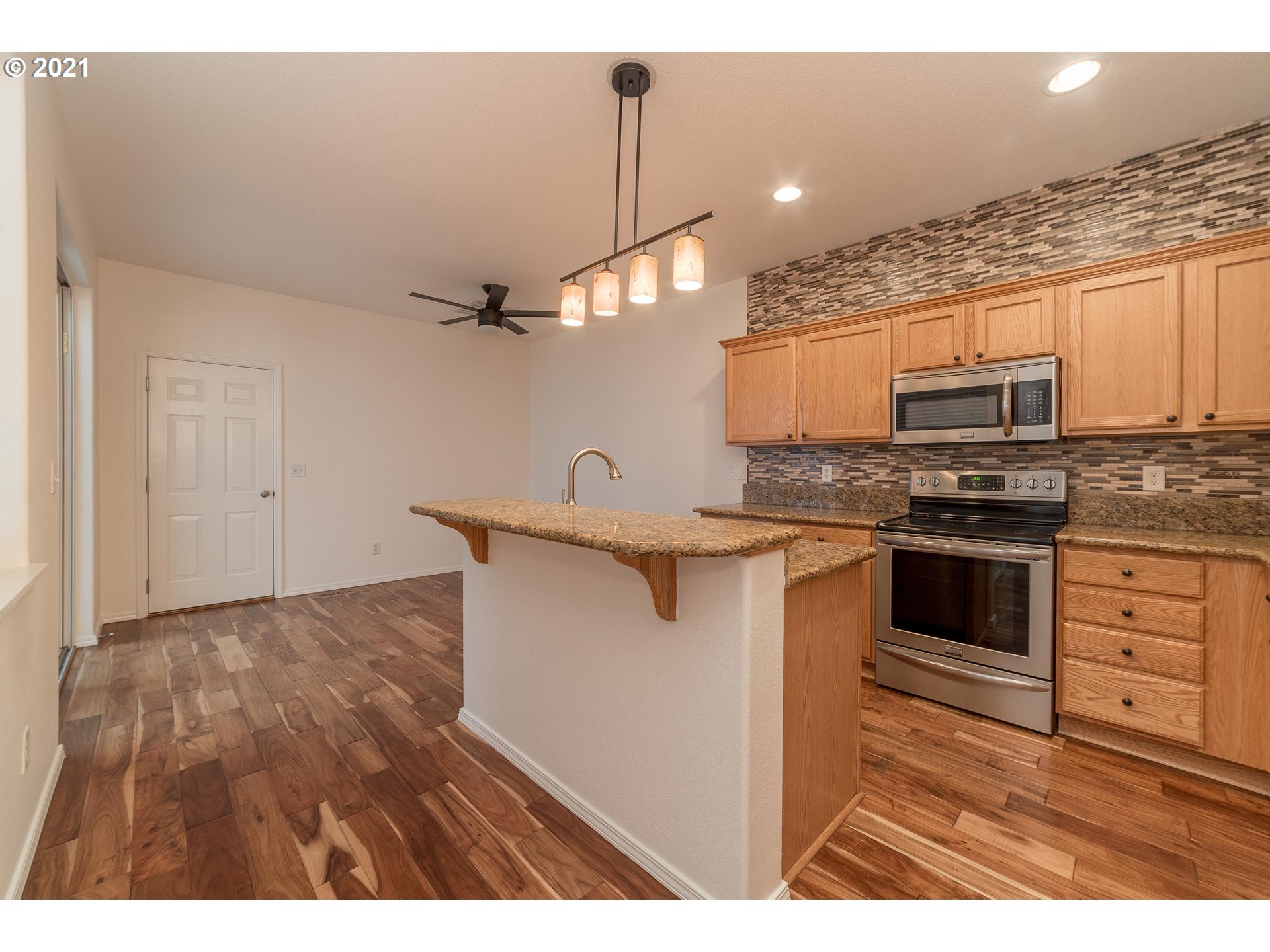 3956 Northwest 12th Avenue Camas, WA 98607 - Photo 5 of 30 a kitchen with stainless steel appliances kitchen island granite countertop a stove a sink and a microwave