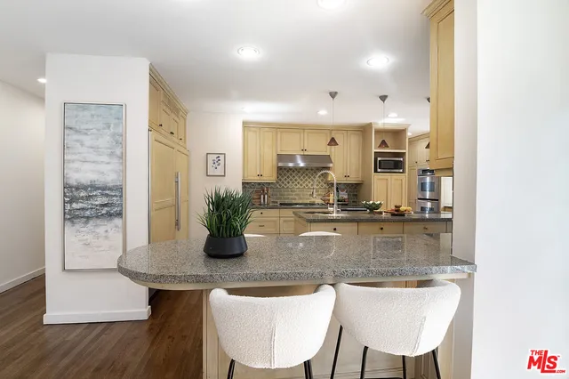 a kitchen with kitchen island granite countertop a table and chairs