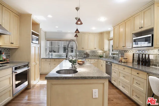 a kitchen with stainless steel appliances granite countertop a sink stove and refrigerator