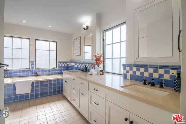 a large kitchen with granite countertop a large window and white stainless steel appliances