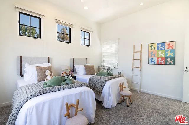 a bedroom with two beds and painting on the wall