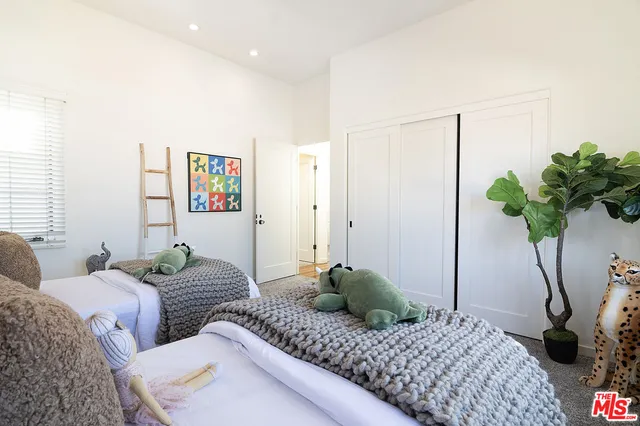 a bedroom with bed and a potted plant
